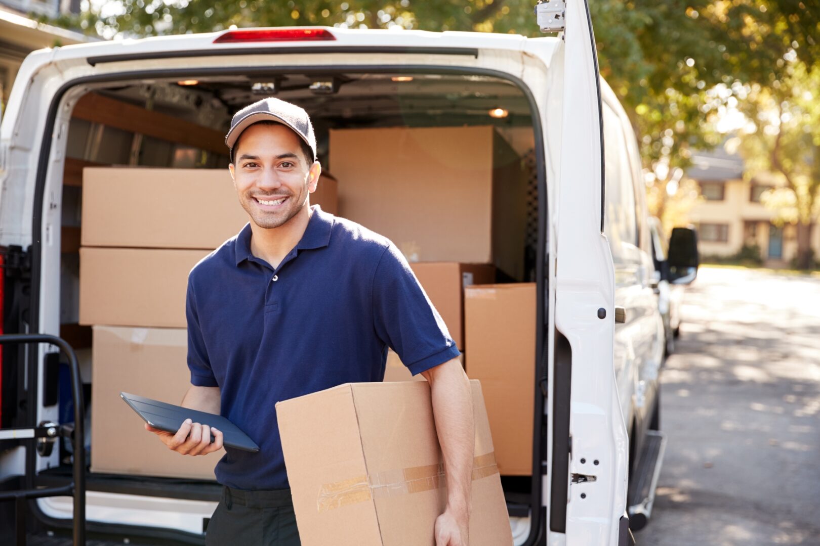 A man in a blue shirt carries a small parcel